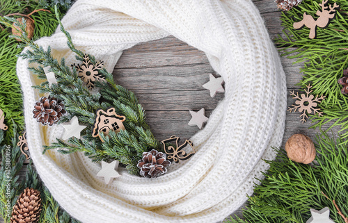 White scarf and spruce branches on a wooden background. photo