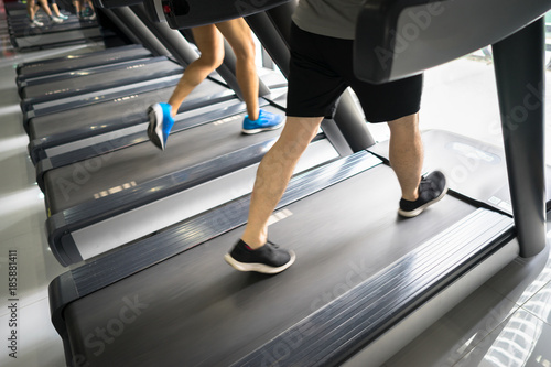 Gym treadmill closeup with man legs running. Concept for exercising, fitness and healthy lifestyle