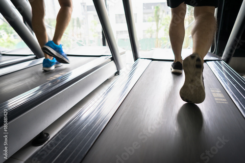 Gym treadmill closeup with man legs running. Concept for exercising, fitness and healthy lifestyle