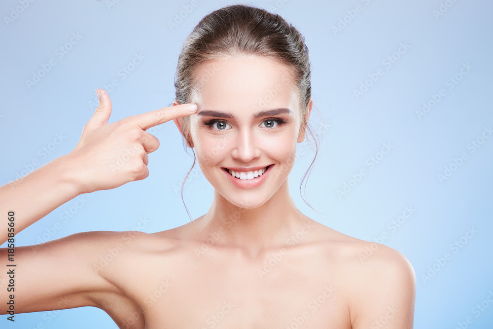 Woman pointing at temple and smiling