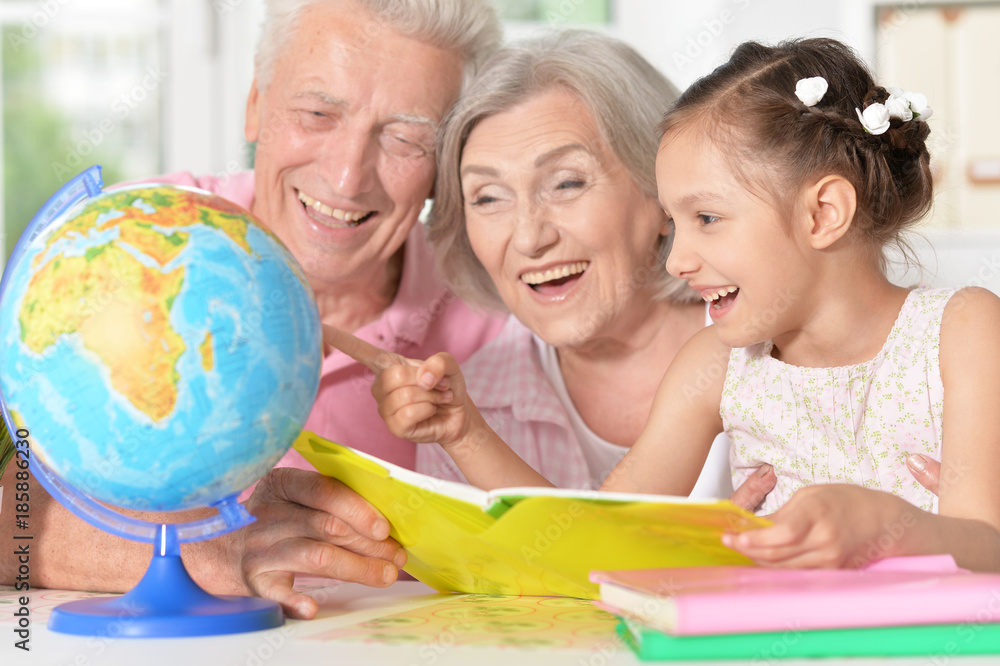girl with grandparents studying at the table girl with grandparents studying at the table