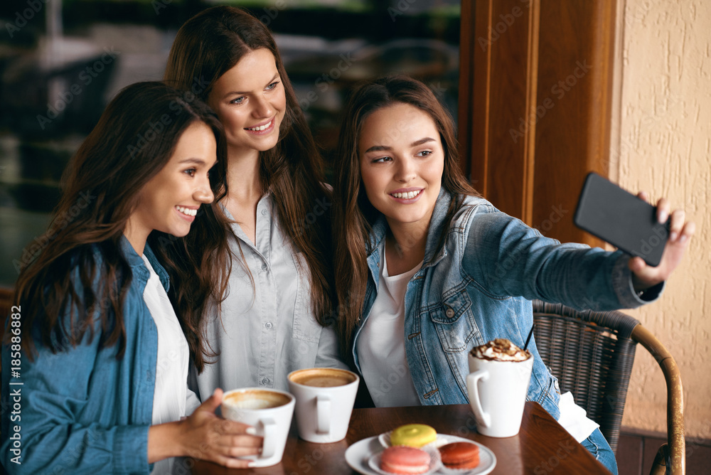 Beautiful Girls In Cafe Taking Selfie Photo On Phone. Beautiful Girls In Cafe Taking Selfie Photo On Phone.