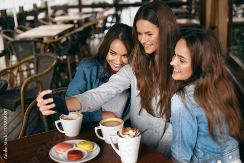 Beautiful Girls In Cafe Taking Selfie Photo On Phone.