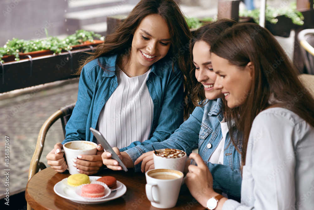 Happy Women Using Phone In Cafe.