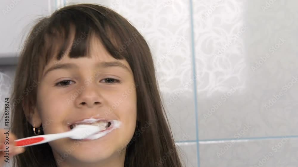 The child cleans his teeth. The girl shows teeth in toothpaste. The child cleans his teeth. The girl shows teeth in toothpaste.