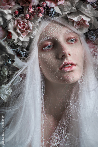 Woman with white hair and white roses and snow on face