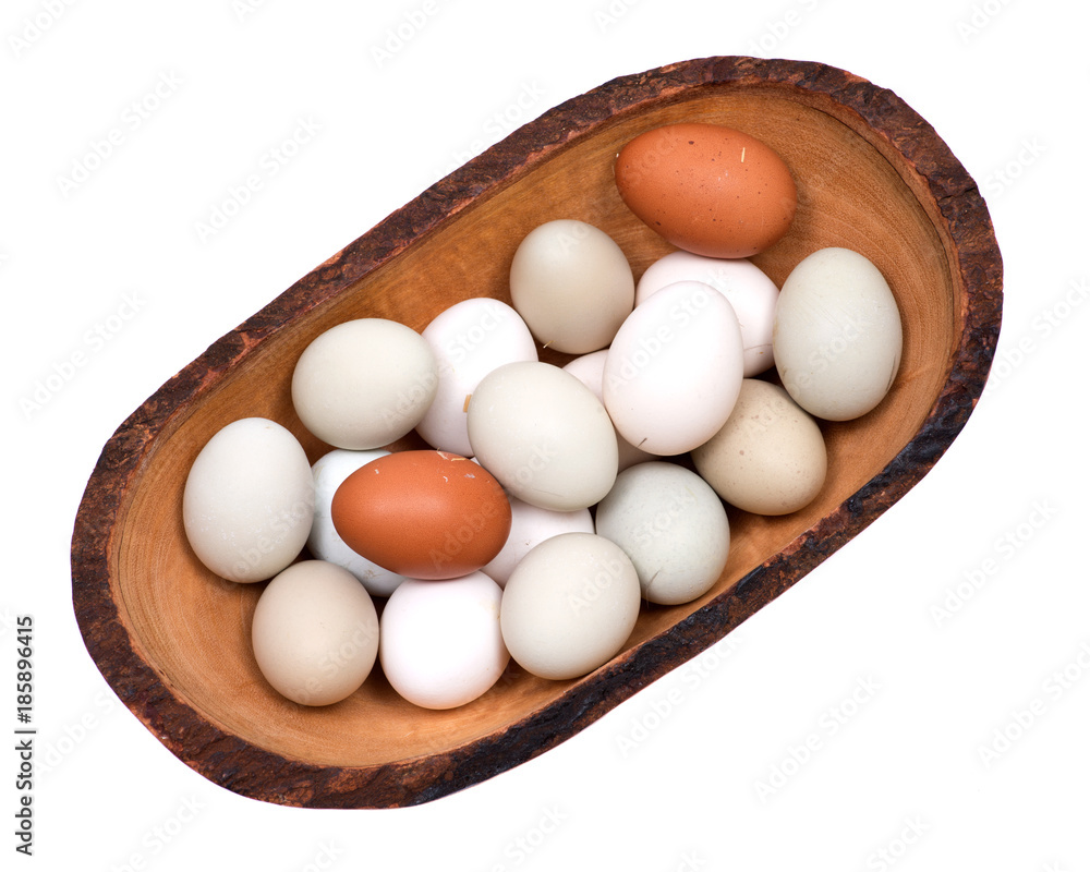 Unwashed fresh organic gmo and soy free pasture raised chicken eggs in wooden bowl isolated on white background Unwashed fresh organic gmo and soy free pasture raised chicken eggs in wooden bowl isolated on white background