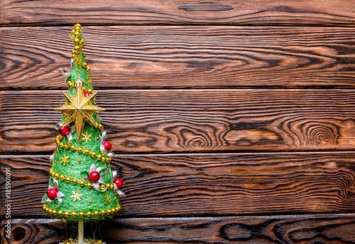 Christmas tree on the brown wooden background 