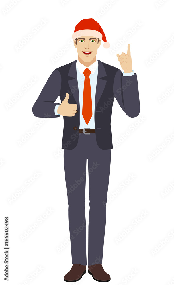 Businessman in Santa hat pointing up and showing thumb up Businessman in Santa hat pointing up and showing thumb up