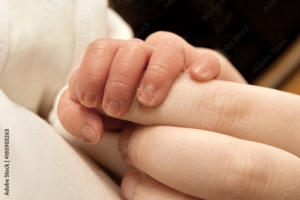 The baby clings to his father's finger The baby clings to his father's finger