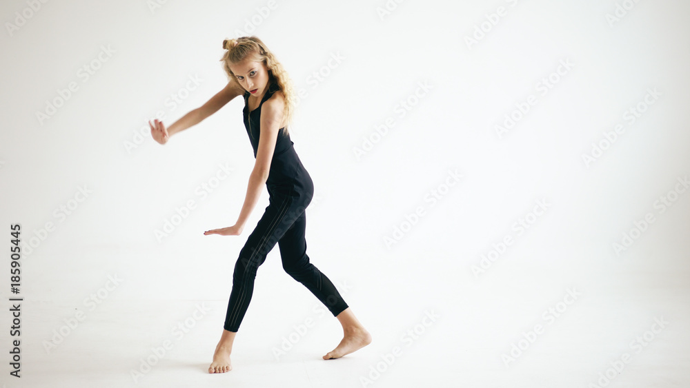 Modern beautiful teenage girl dancer dancing contemporary on white background indoors Modern beautiful teenage girl dancer dancing contemporary on white background indoors