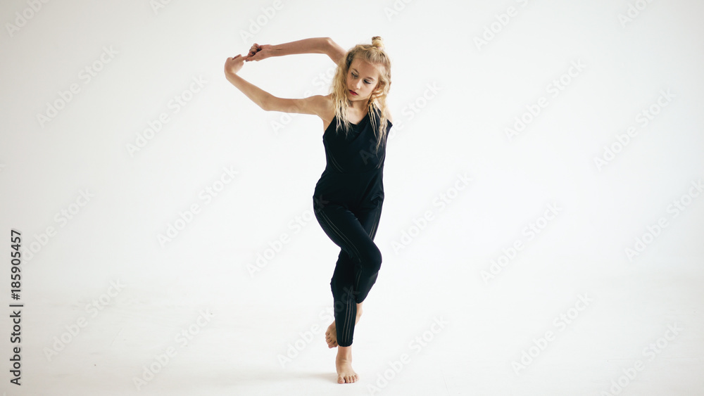 Modern beautiful teenage girl dancer dancing contemporary on white background indoors