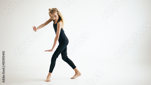 Modern beautiful teenage girl dancer dancing contemporary on white background indoors