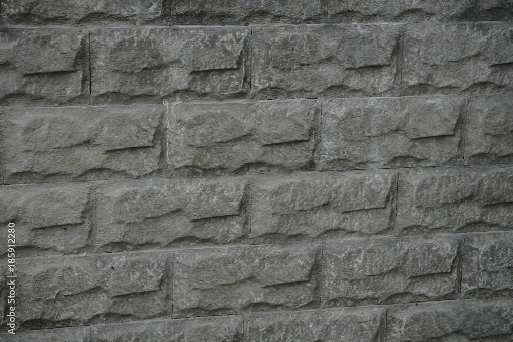 The texture of a stone fence with rectangular blocks and concrete seams.
