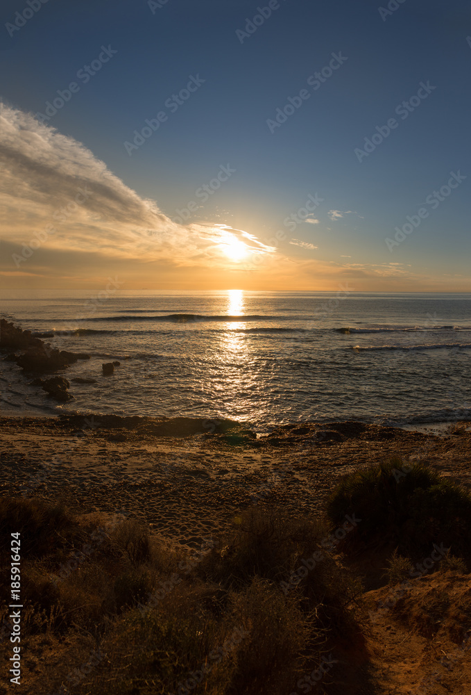 The calm sea in a very cloudy sunset