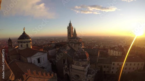 Bergamo, Italy. The old city. Timelapse aerial view of the Basilica of Santa Maria Maggiore and the chapel Colleoni during the sunset. In the background the Po plain