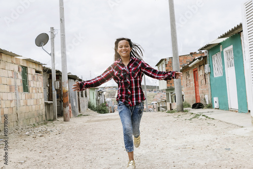 Fotografie Beautiful girl running in shanty town.