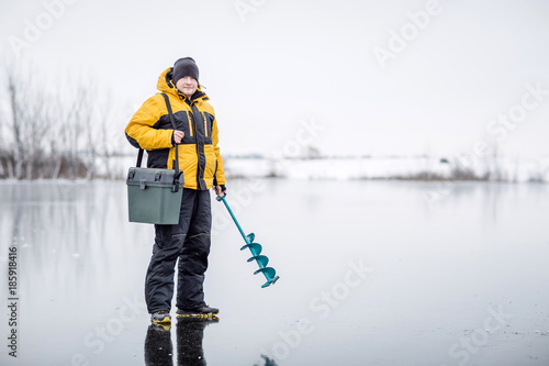 Mężczyzna lodowy połów na zamarzniętym jeziorze.