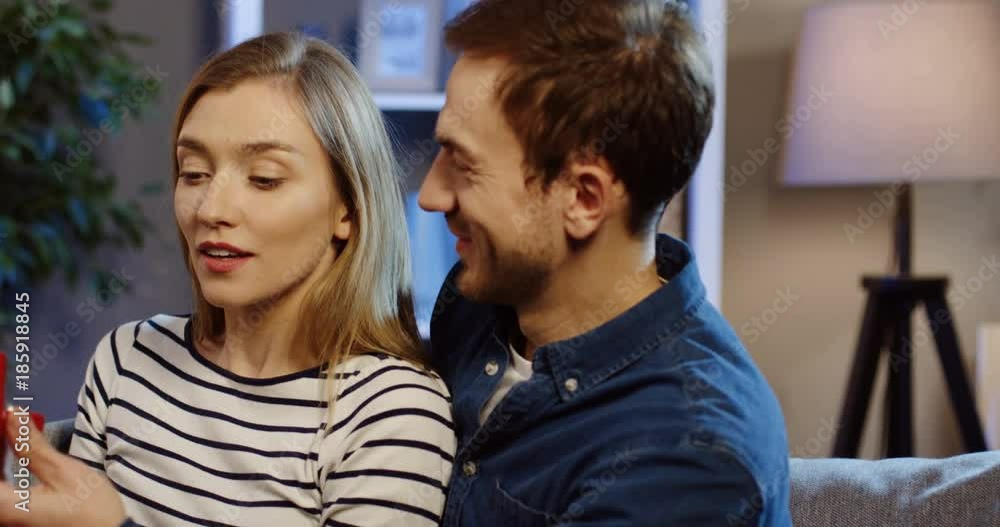 Close up of the handsome Caucasian man proposing to the blonde pretty woman with an engagement ring and she refusing. At home. Indoor Close up of the handsome Caucasian man proposing to the blonde pretty woman with an engagement ring and she refusing. At home. Indoor