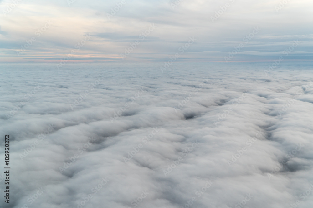 View from an airplane above the clouds during blue hour