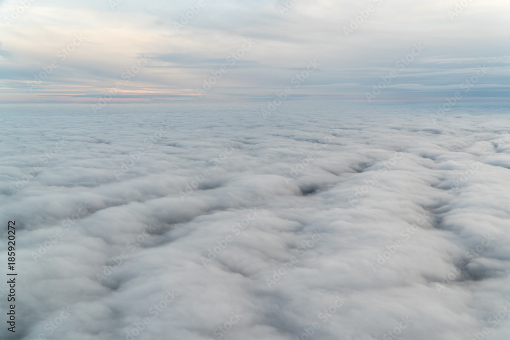 View from an airplane above the clouds during blue hour View from an airplane above the clouds during blue hour