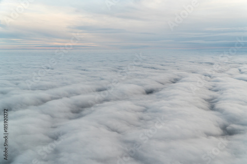 View from an airplane above the clouds during blue hour
