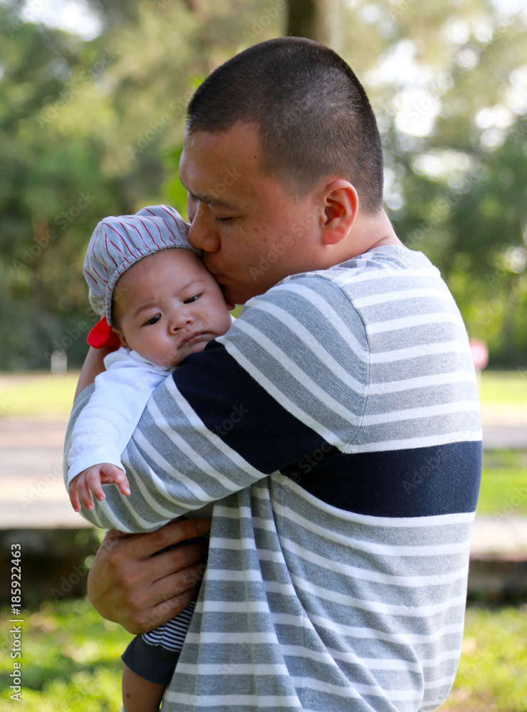 A happy father holding his newborn son with love A happy father holding his newborn son with love