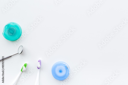 Teeth care. Toothbrushes, floss, dental mirror on white background top view copyspace