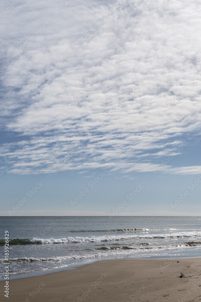 view of a quiet beach with clouds on the horizon