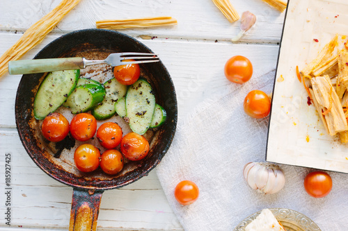 Frying pan with roasted cherry tomatoes and cucumbers.