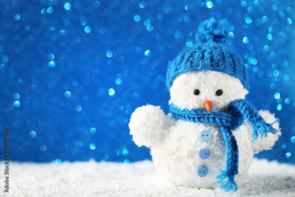 Small snowman toy on blue lights background Small snowman toy on blue lights background