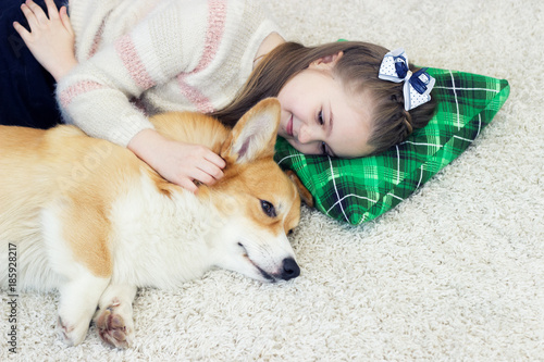child and dog lie on a fluffy carpet top view
