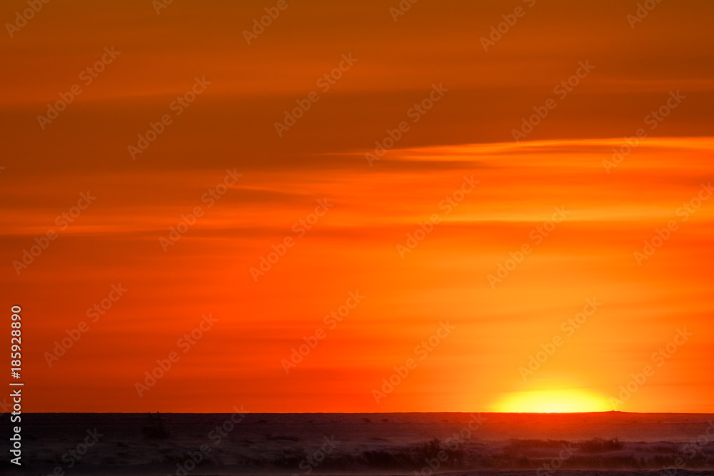 Vivid yellows, oranges, and reds of sunset over the frozen tundra of Hudson Bay, Manitoba, Canada
