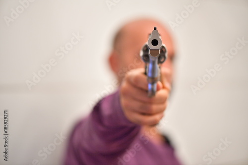A young man aims with a gun.