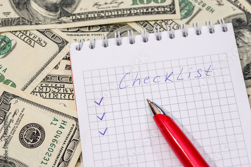 Checklist on a notepad with money and pen