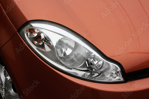 Car headlight car. The car is an orange color. Lighting devices of transport. © Denys