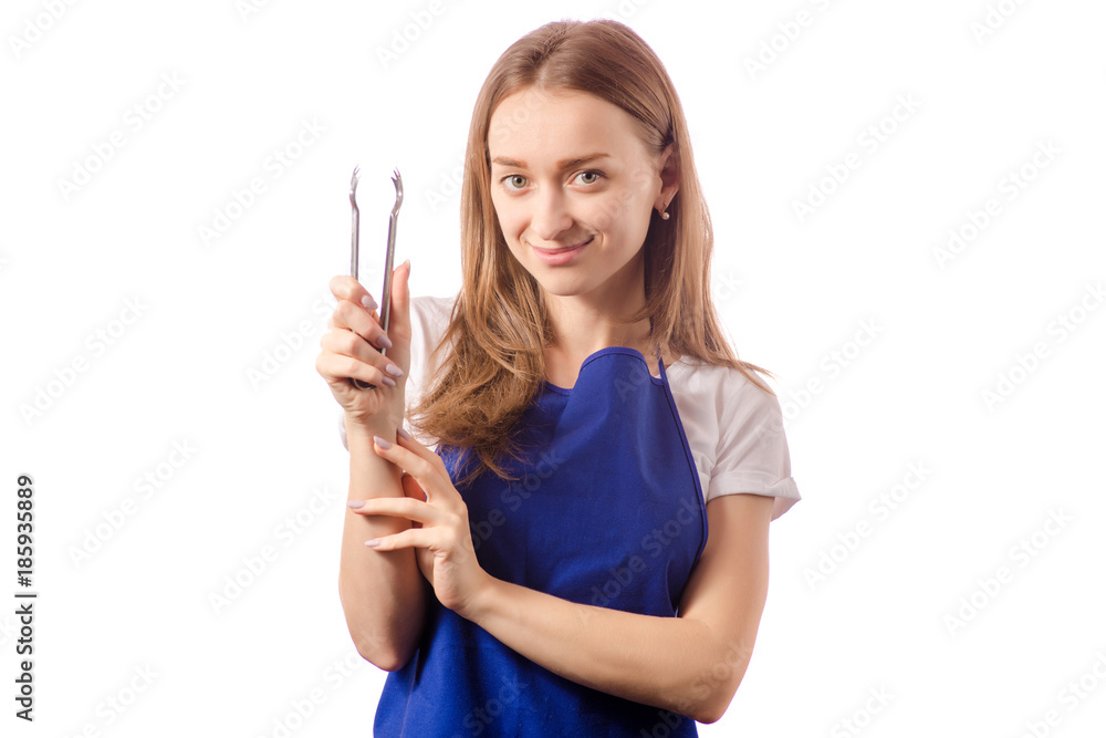 Young woman cook in apron in the hands kitchen tongs silver Young woman cook in apron in the hands kitchen tongs silver