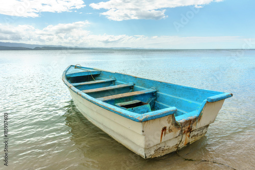 empty old wooden boat on shallow water