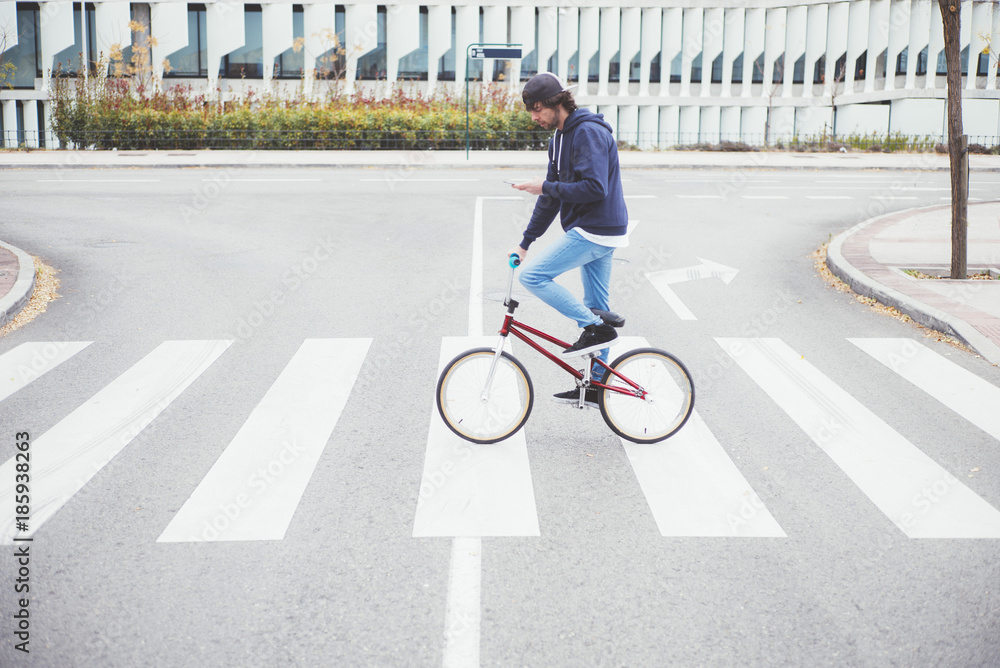 Fototapeta premium Male BMX rider on street with phone