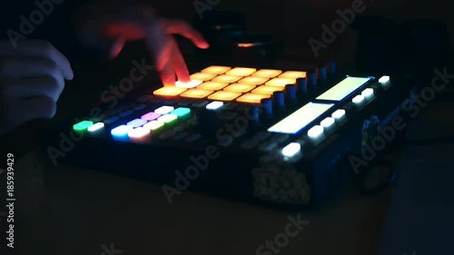 dj adjusting audio setting on the audio controller drum machine and playing music in the club