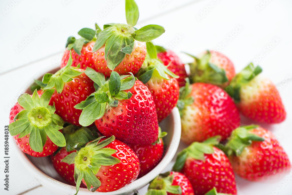 Closeup the red strawberry in big bowl put on timber board,plenty of blurred strawberry on board,blurry light around. Closeup the red strawberry in big bowl put on timber board,plenty of blurred strawberry on board,blurry light around.