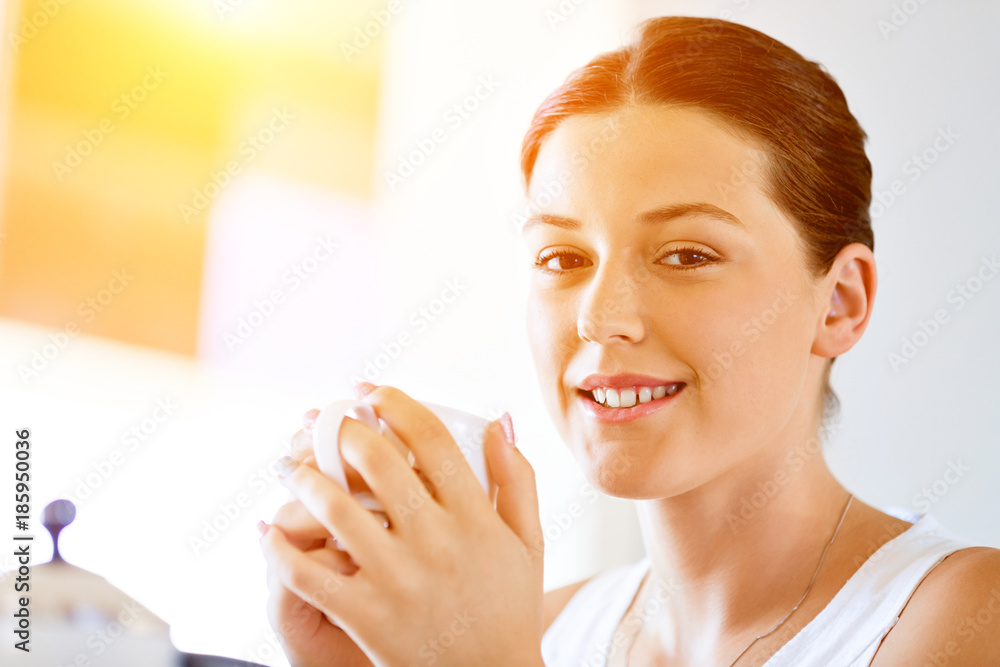 Happy young woman with cup of tea or coffee at home Happy young woman with cup of tea or coffee at home