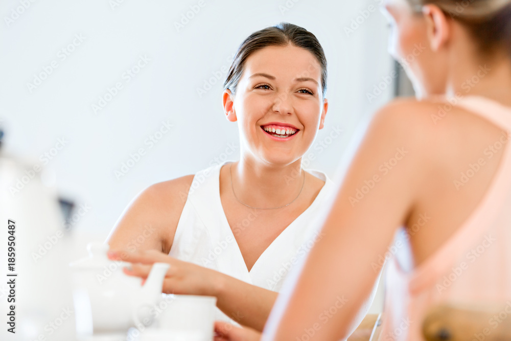 Young woman with her friend having tea at home Young woman with her friend having tea at home