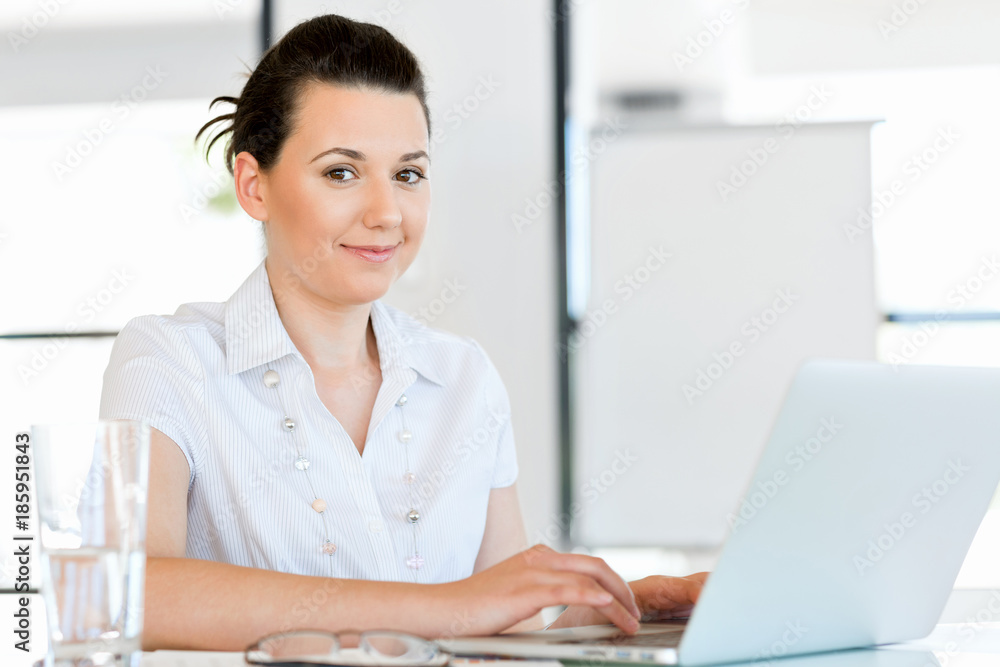 Portrait of businesswoman working at computer in office Portrait of businesswoman working at computer in office