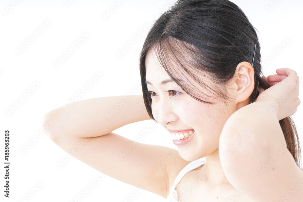 Young woman tying her hair Young woman tying her hair