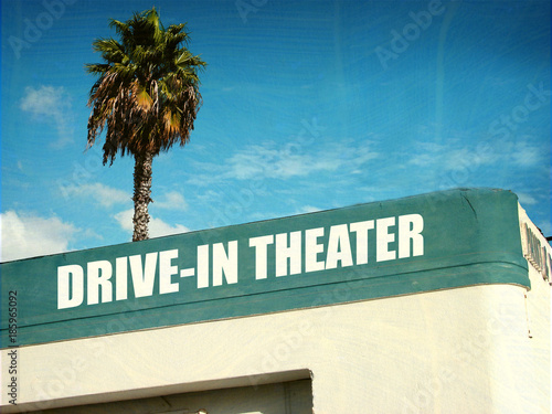 aged and worn drive in tehater sign with palm trees