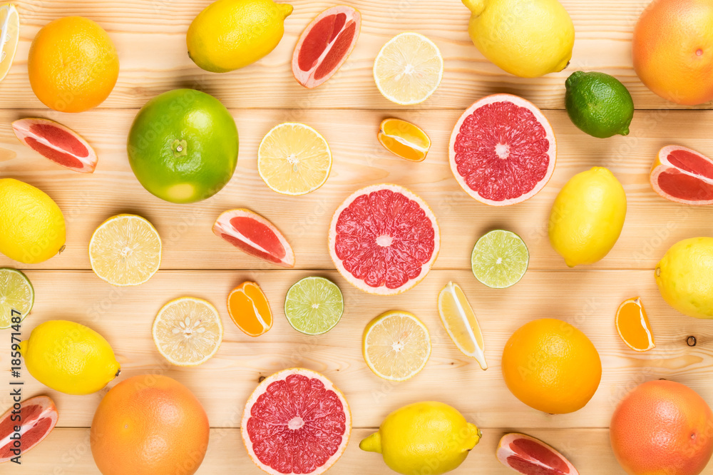 different tasty citrus fruits on a light wooden table