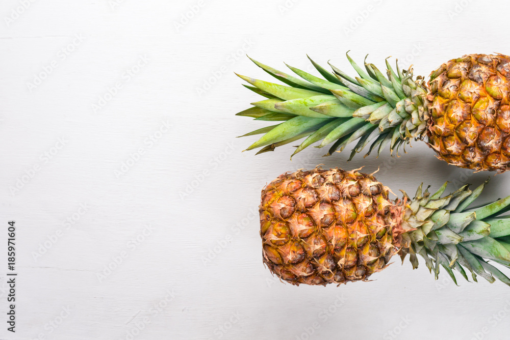 Fototapeta premium Pineapple on a wooden background. Top view. Free space for text.