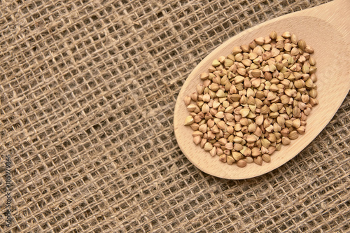 Buckwheat grains. Healthy food. Neutral background. Wooden spoon