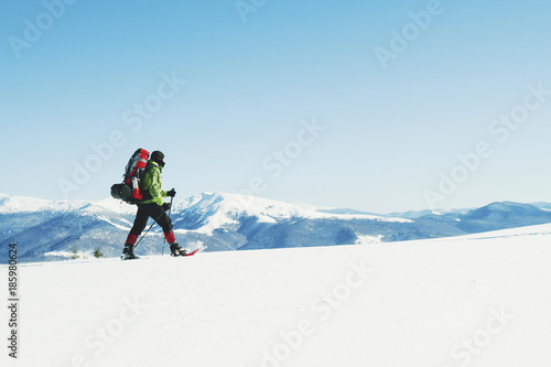 Winter hike in the mountains with a backpack and tent.